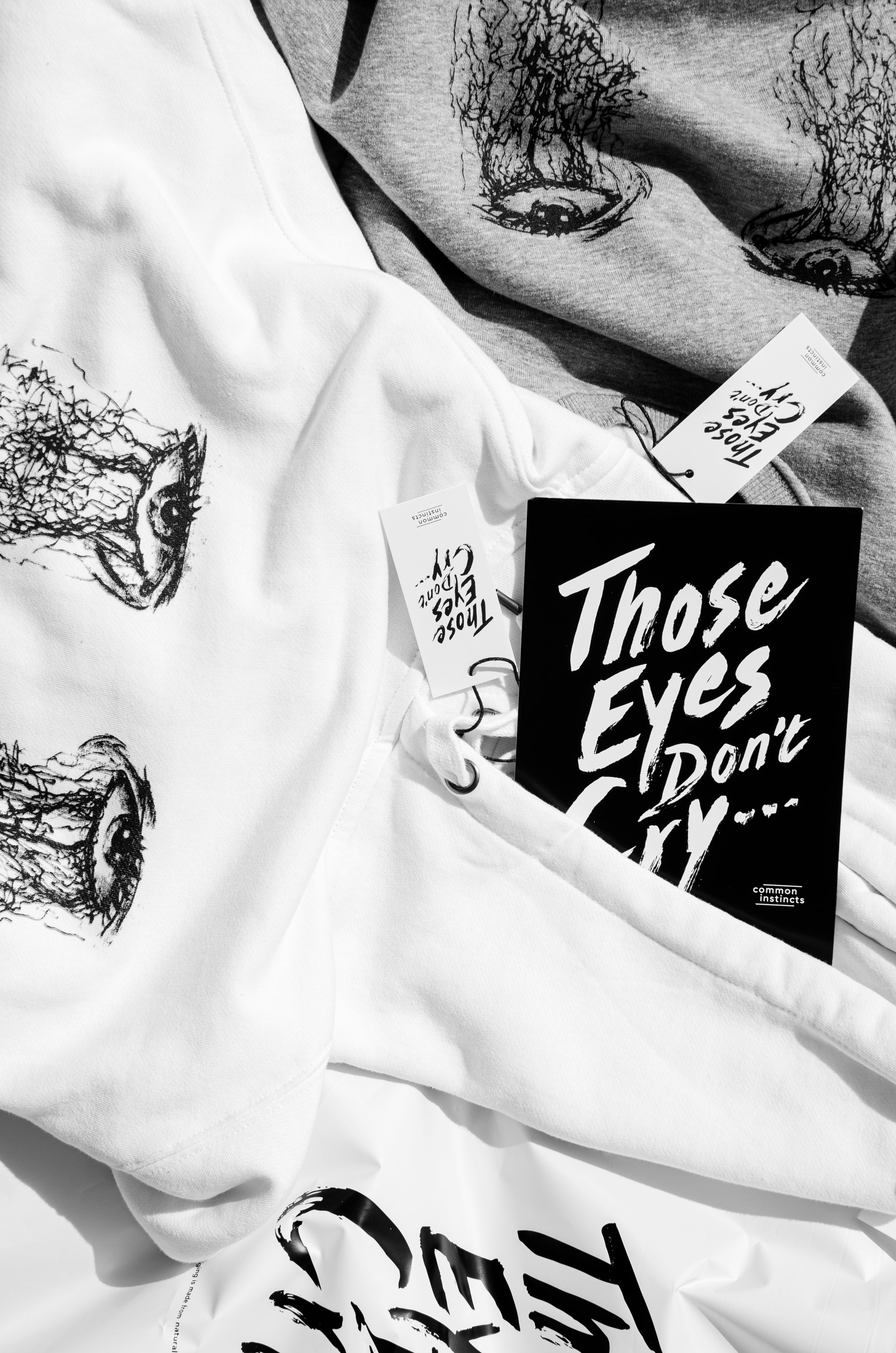 White Hoodie and Grey Sweater with silk-screen-printed ink illustration of eyes, and branded cards, high-quality artistic pullovers, for a cool, bold statement 01